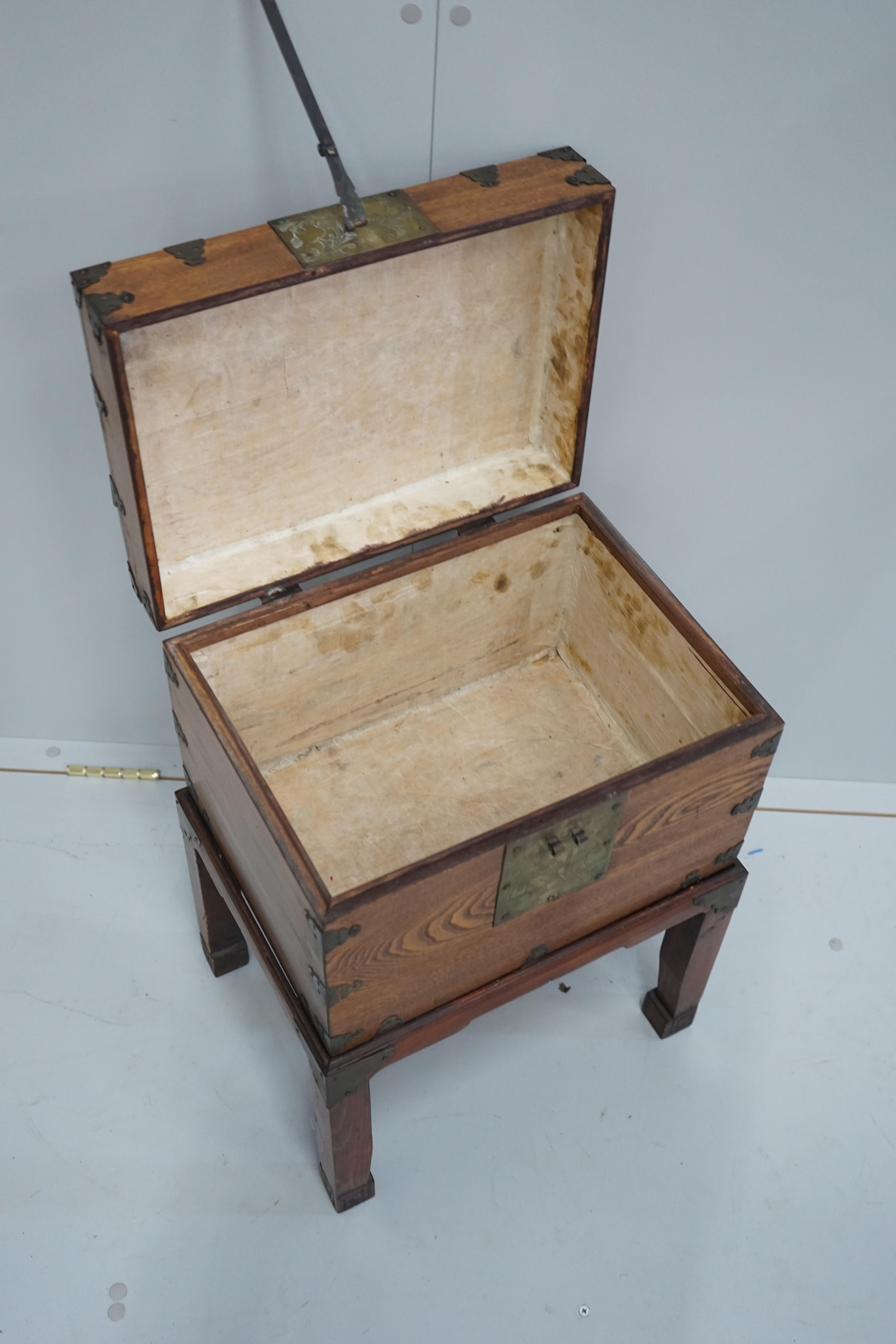 A Chinese brass mounted elm box on stand, width 42cm, depth 31cm, height 59cm